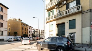Straatbeeld met geparkeerde auto's, gebouwen en een voetgangersoversteek.