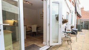 Ein Wohnhaus mit Glastür, die zu einem Essbereich mit Tisch und Stühlen führt.