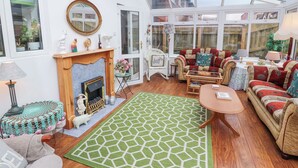A cozy living room with a fireplace, comfortable seating, and a large window. - Marwood (Penrith)