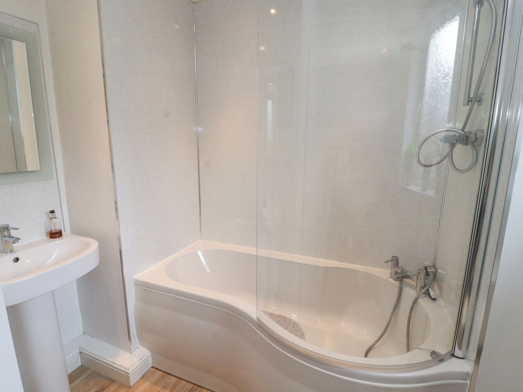 A modern bathroom with a freestanding bathtub, a glass-enclosed shower, and a white sink.
