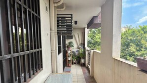 A narrow balcony with a metal railing, a small table, and potted plants. - Spacious 3BR Senja Pasig Home - Sleeps Up To 9! (Pasig)