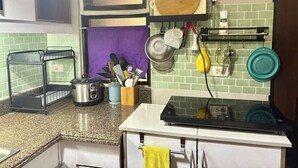 A kitchen with a granite countertop, a gas stove, a sink, and various kitchen utensils and appliances. - Spacious 3BR Senja Pasig Home - Sleeps Up To 9! (Pasig)