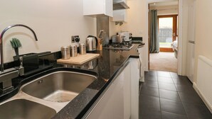 Cocina moderna con electrodomésticos de acero inoxidable, un lavamanos doble y encimera de madera.