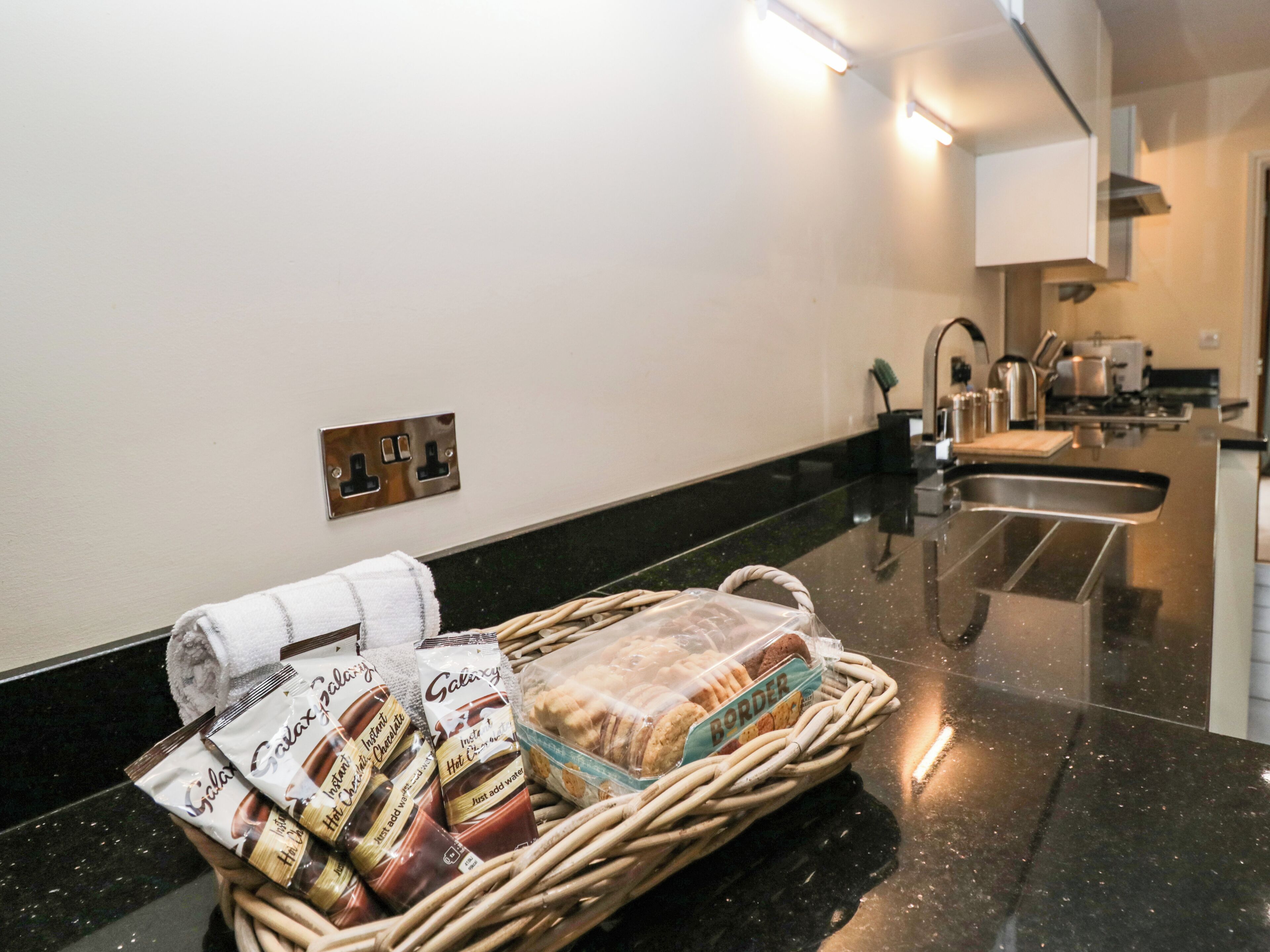 Une cuisine avec un plan de travail, un panier de collations et une serviette.
