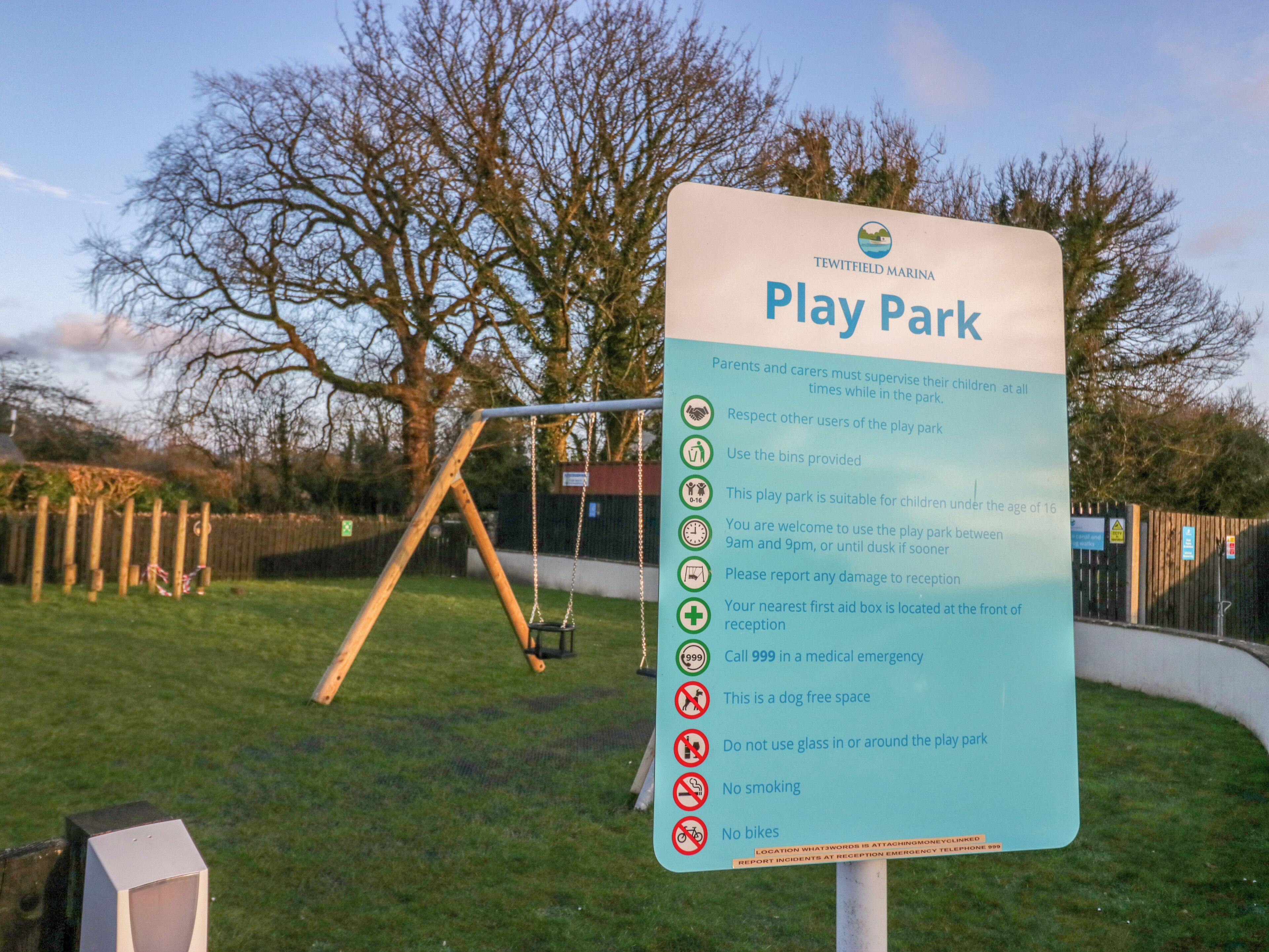 A sign for a play park with rules and guidelines for visitors.