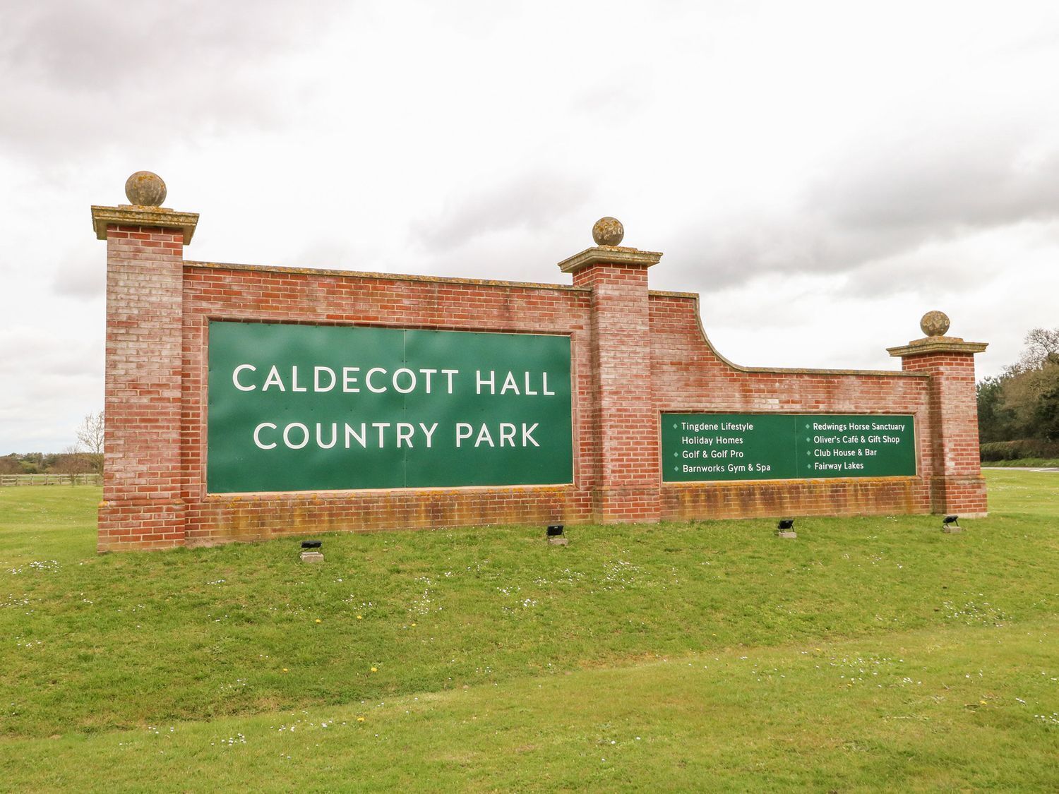 A sign for Caldecott Hall Country Park listing amenities like Tingdene Lifestyle, Redwings Horse Sanctuary, and more.