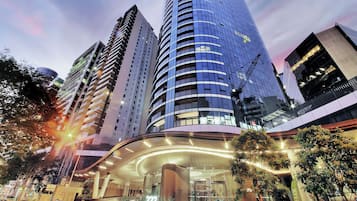 A modern hotel with a curved entrance, multiple floors, and a prominent sign indicating the name.