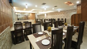 Un restaurante con varias mesas y sillas, dispuesto en un espacio amplio.