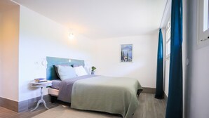 A neatly arranged bedroom with a bed, bedside table, and a wall-mounted lamp. - Venez Chez Vous Appartement Aux Premières Loges (Sévrier)