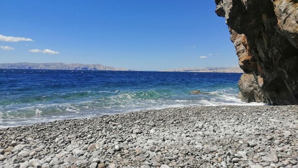 A rocky beach with clear blue sea and distant mountains. - Apartment in Croatia near Adriatic Coast (Senj)