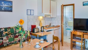 A compact living space with a kitchenette, a dining area, and a TV. - Apartment in Croatia near Adriatic Coast (Senj)
