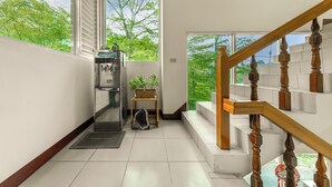 A modern hotel room with a large window, a wooden staircase, and a small table with a potted plant. - Taomi Mountain Lodge (Puli)