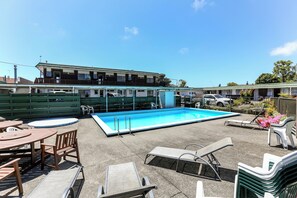 Relax by the pool surrounded by lounge chairs and a small table.
