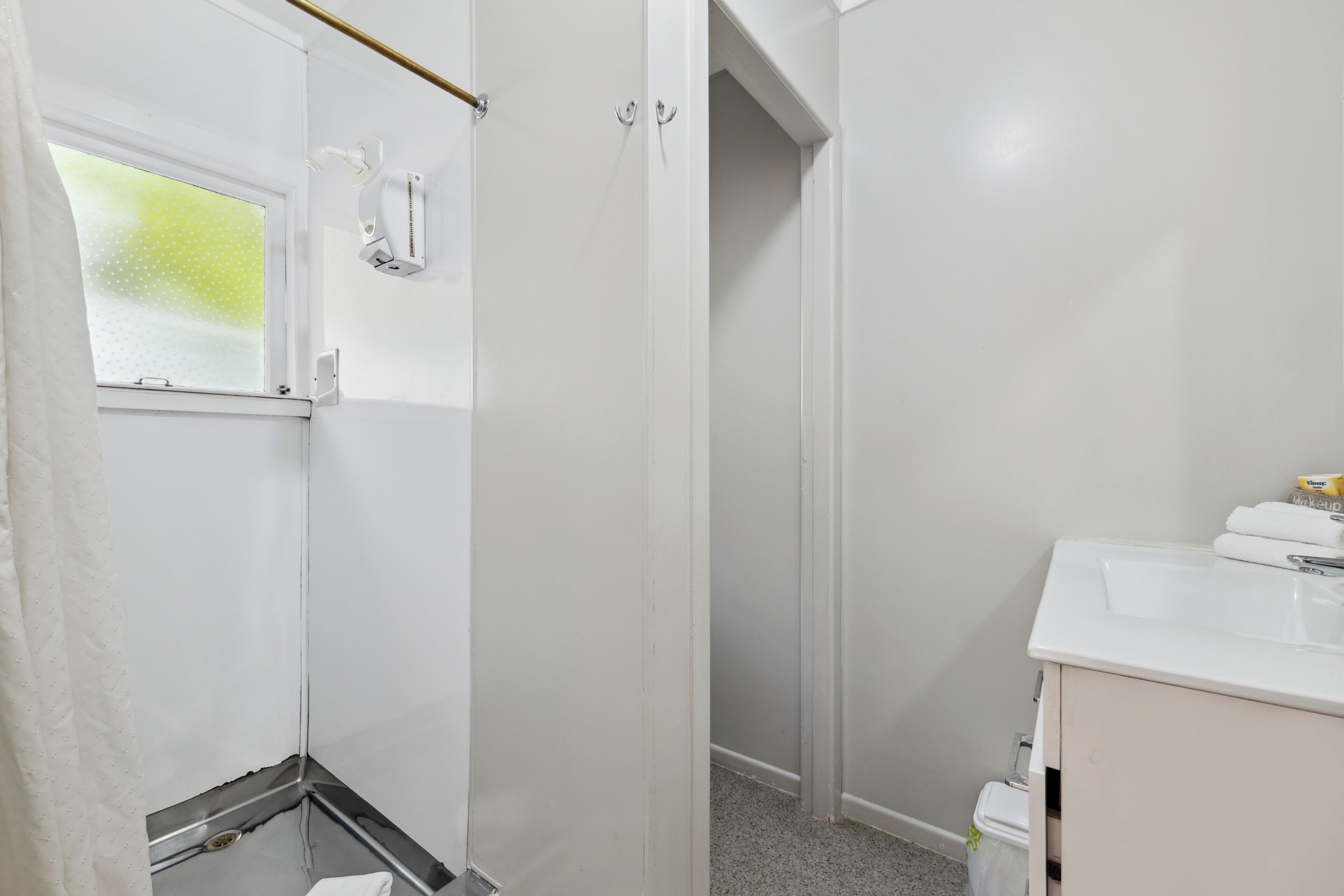 A bathroom with a shower, a sink, and a toilet.