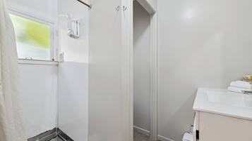 A bathroom with a shower, a sink, and a toilet.