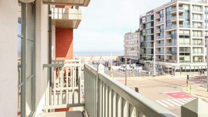 A balcony with a view of a modern building and a street.