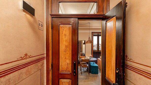 A wooden door leading to a dining area with a table and chairs. - Central Porto Stay with Balcony (Oporto)