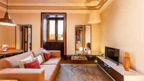 A modern living room with a sofa, television, and decorative items. - Central Porto Stay with Balcony (Oporto)