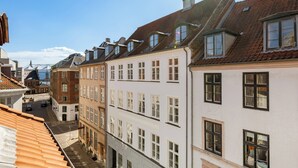 A narrow street lined with traditional European buildings, featuring steeply pitched roofs and uniform window designs.