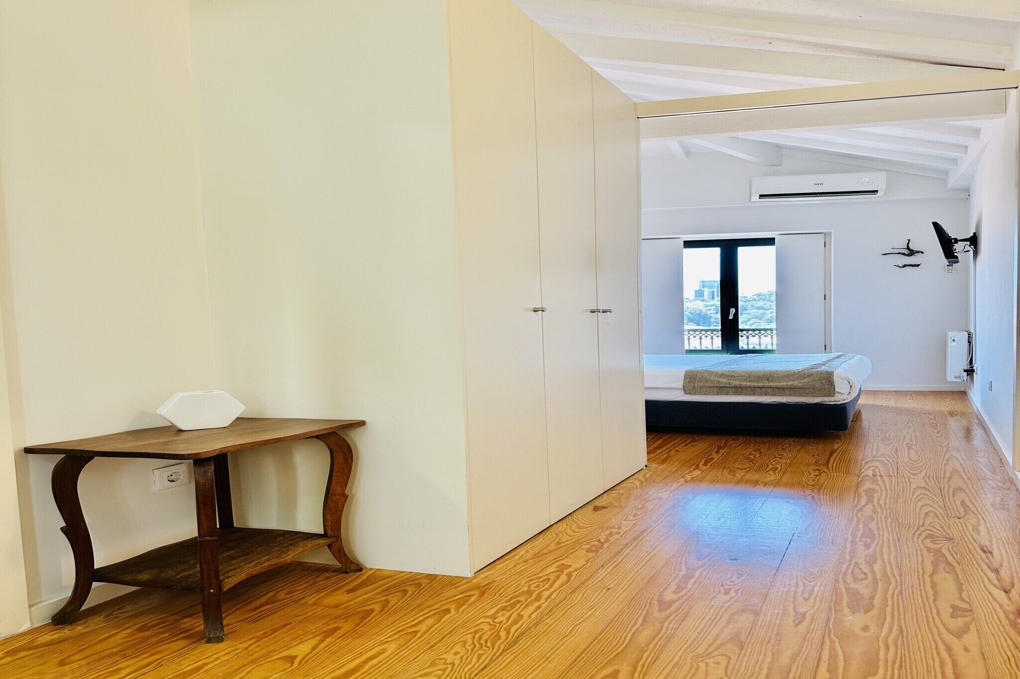 A room with a bed, a desk, and a wardrobe.