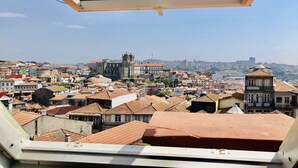 A cityscape viewed from a high vantage point, likely from a hotel room with a skylight. - Cozy City Family Retreat (Oporto)