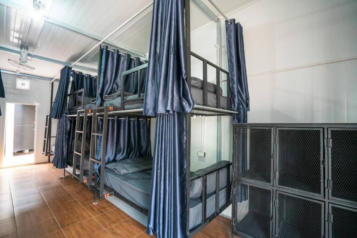 Quarto com beliche, escada e divisória de tela.