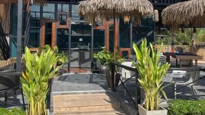 A modern building with a thatched roof structure, a wooden pergola, and potted plants. - Summer Club and Hostel Ao Nang (Krabi)