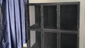 A room with a metal cabinet with mesh doors and a dark blue curtain. - Summer Club and Hostel Ao Nang (Krabi)