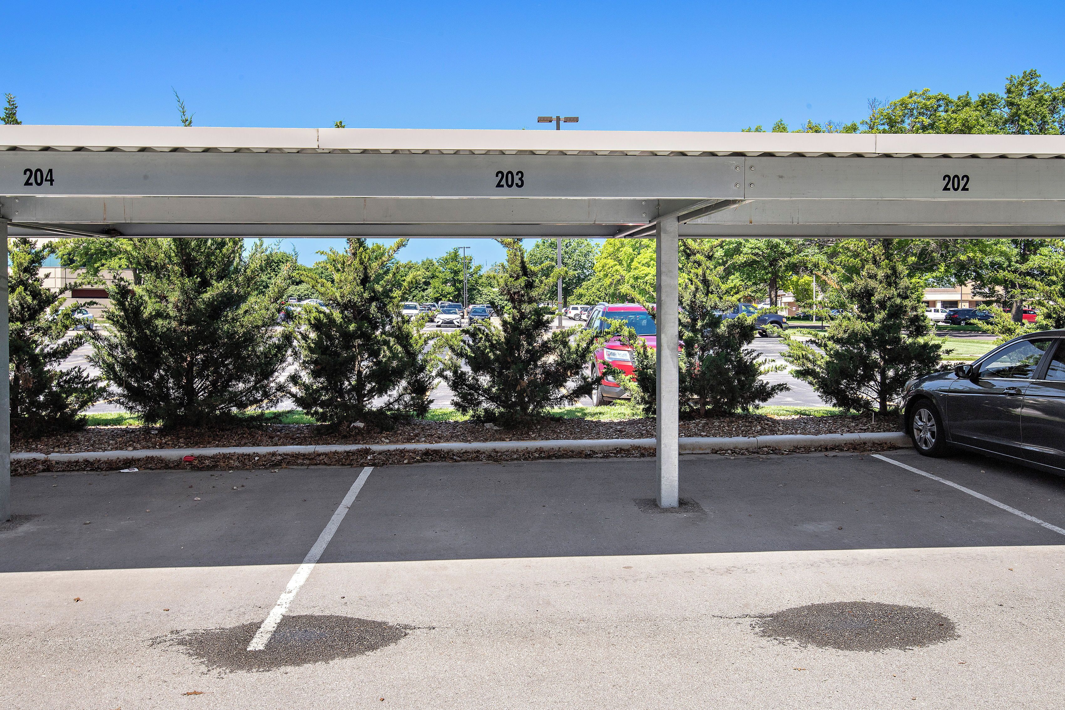 A parking structure with numbered parking spaces 202, 203, and 204.