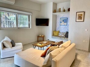 Departamento familiar, vista parcial al mar | Sala de estar | Televisión de pantalla plana 