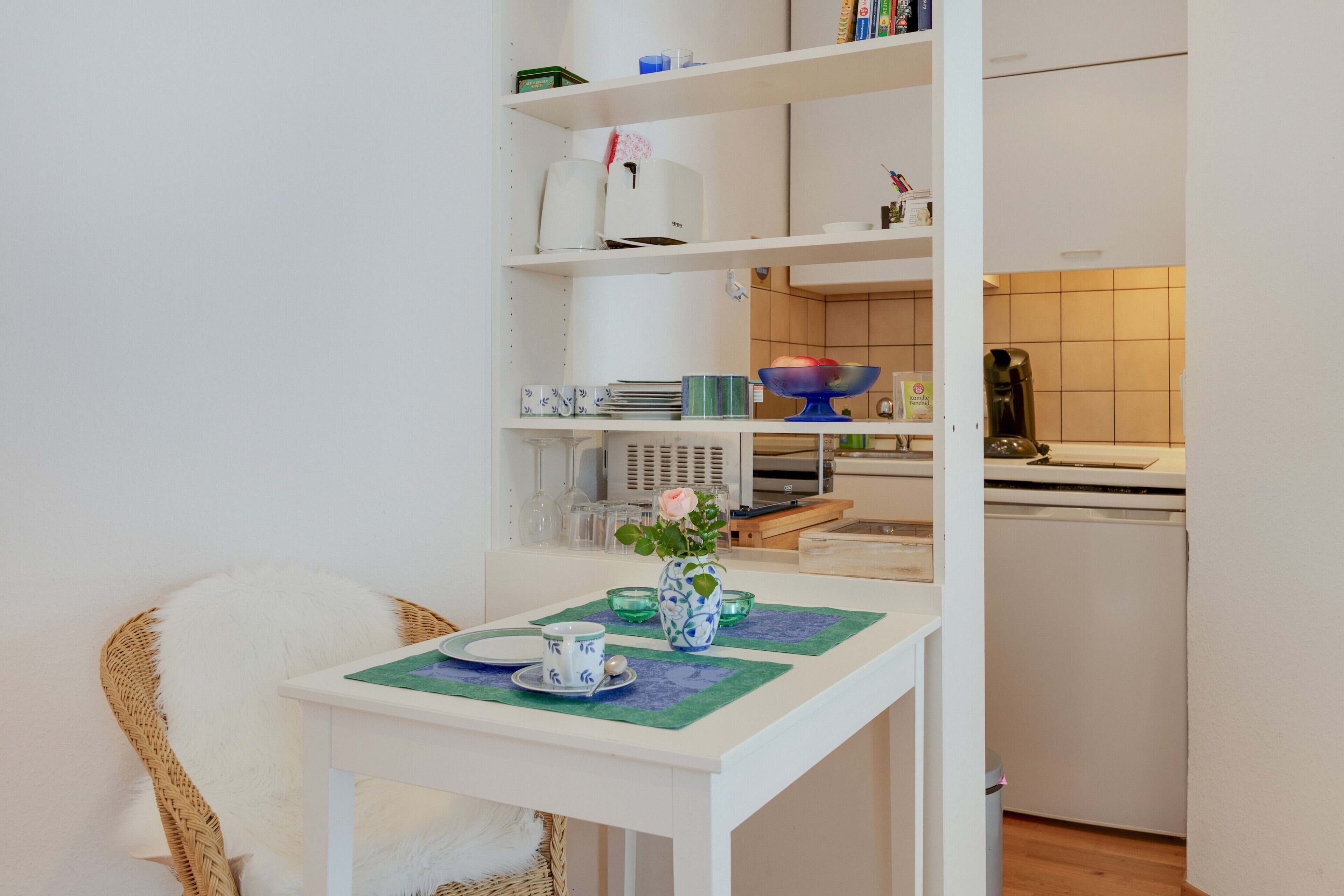 Eine kleine Küchenzeile mit Kaffeemaschine, Mikrowelle und Toaster.