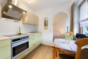 Une cuisine équipée d’une cuisinière, d’un four et de placards.