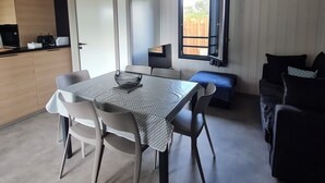 A compact living space with a dining area, kitchenette, and a window with a view of the outside. - Agde Prestige Chalet in private residence with Pools and Spa (Agde)