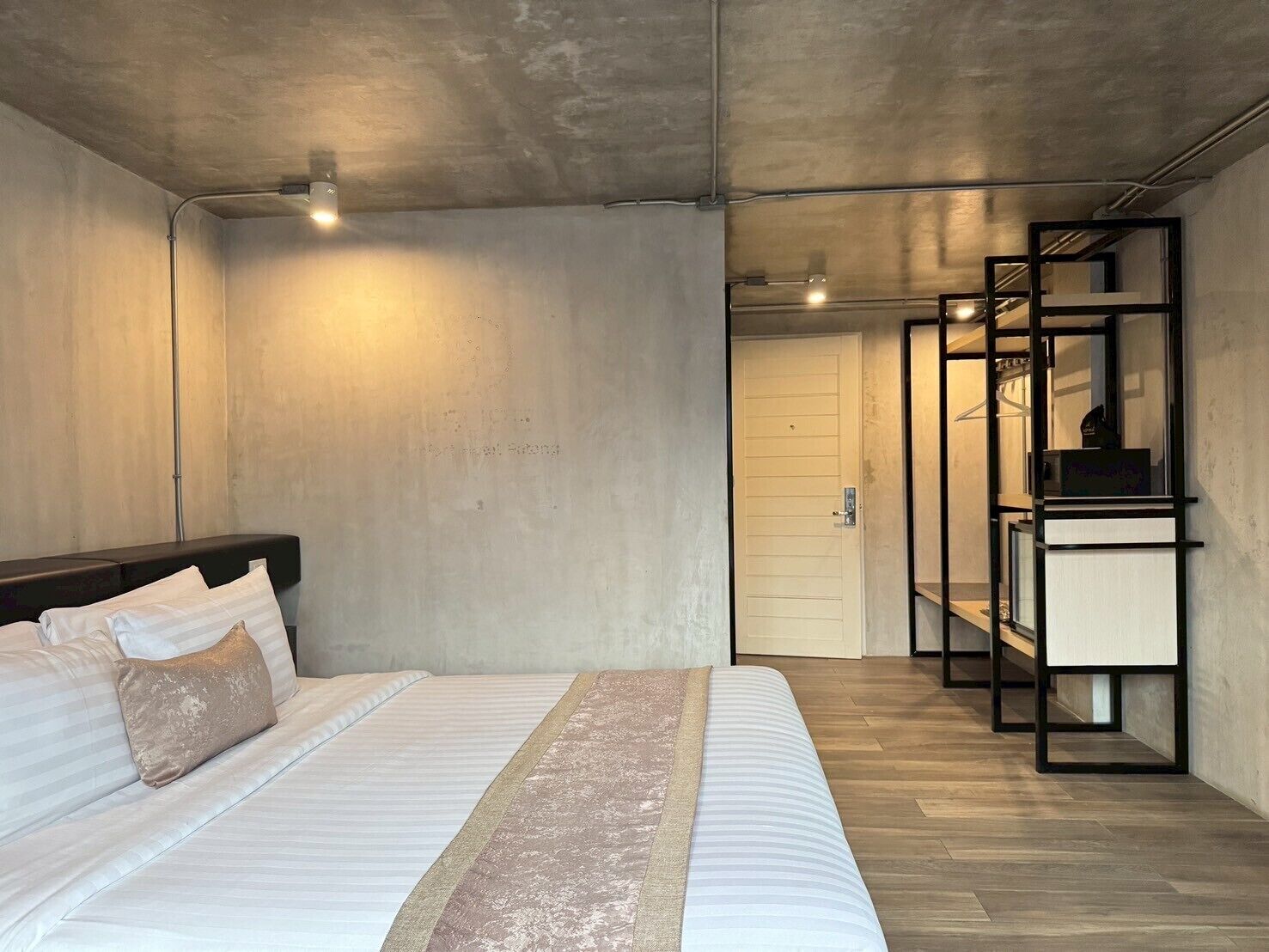 A bedroom with a bed, a wardrobe, and a door leading to another room.