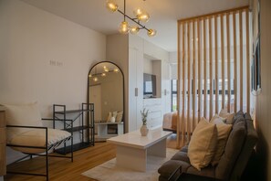 Relax in this stylish living space with a comfortable sofa, a bed, and a large mirror.