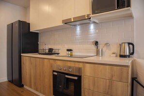 Enjoy cooking in this well-equipped kitchen with a refrigerator, oven, microwave, coffee maker, and kettle.