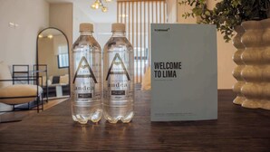 Two bottles of water and a welcome sign on a wooden table in a modern interior. - w* | Modern 1BR in San Isidro (Lima)