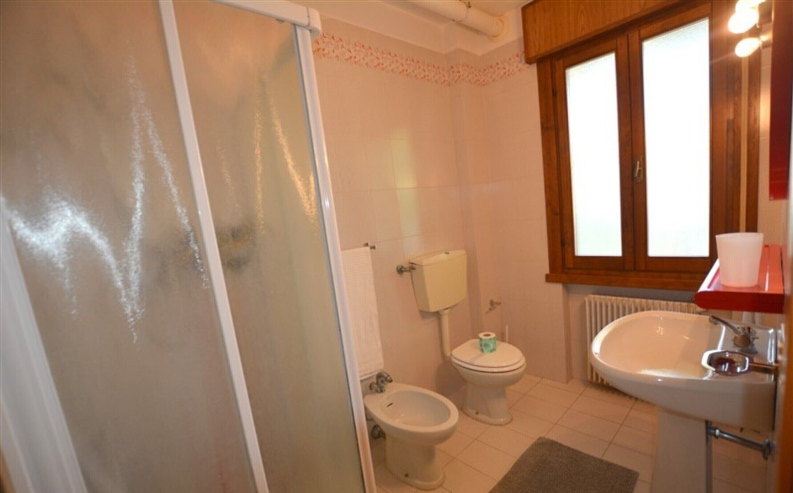 A bathroom with a toilet, bidet, and sink.