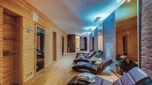 A spa with wooden walls, a massage area with leather chairs, and a visible shower room. - Landhotel Lewitz Mühle (Banzkow)