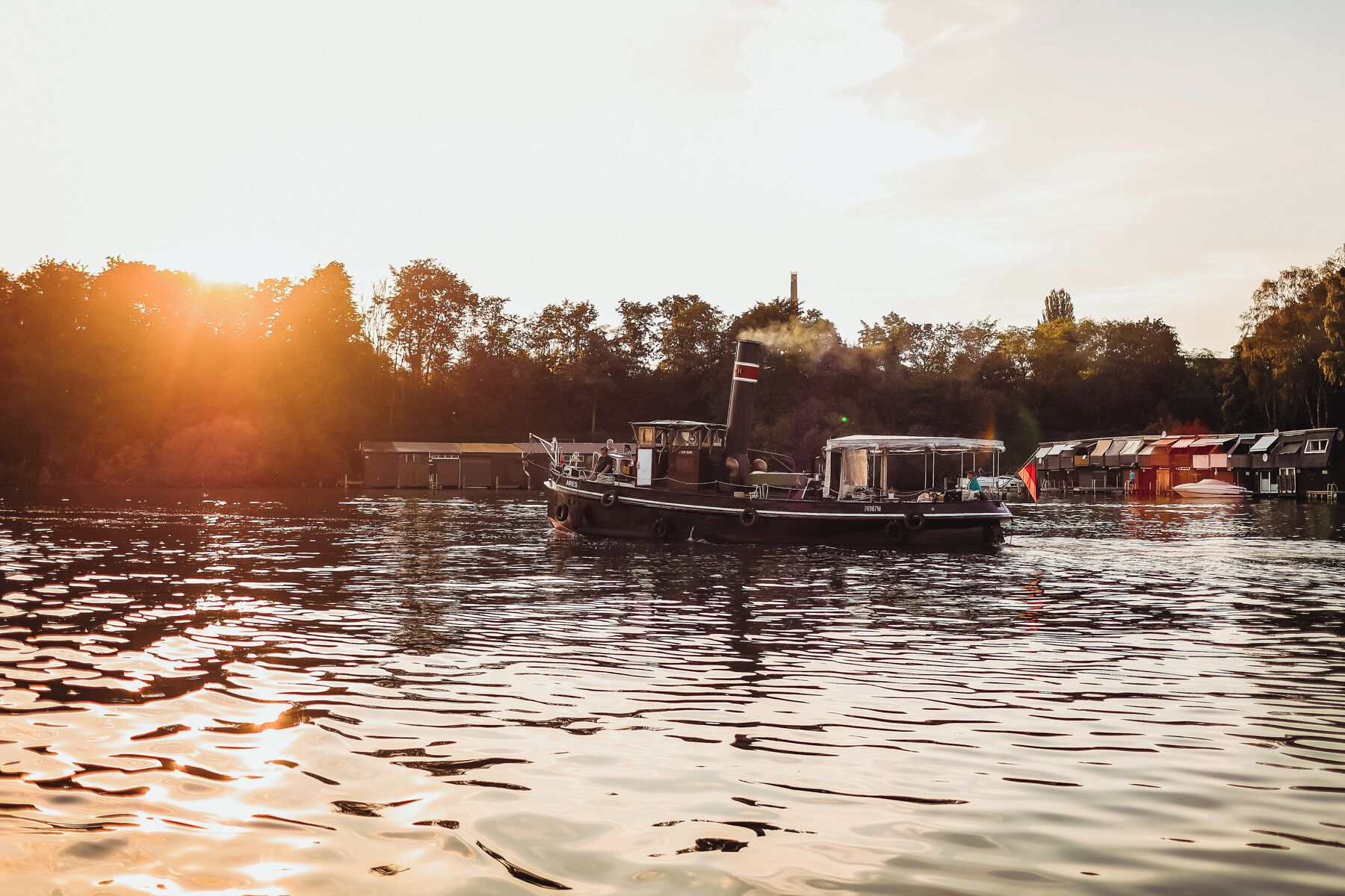 Un bateau était amarré dans une marina, et la surface calme de l’eau reflétait la lumière du soleil.