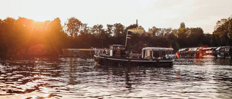 Un bateau était amarré dans une marina, et la surface calme de l’eau reflétait la lumière du soleil.
