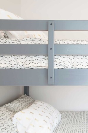 A bunk bed with a grey frame and patterned bedding. - Adorable Broad Ripple Duplex! (Indianapolis)