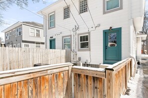 A two-story house with a wooden fence and a blue door.