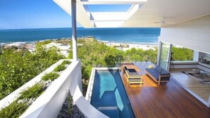 A modern house with a pool, wooden deck, and a view of the ocean. - Coolum Bays Beach House - Discover ultimate luxury at this award-winning architectural masterpiece. (Coolum Beach)