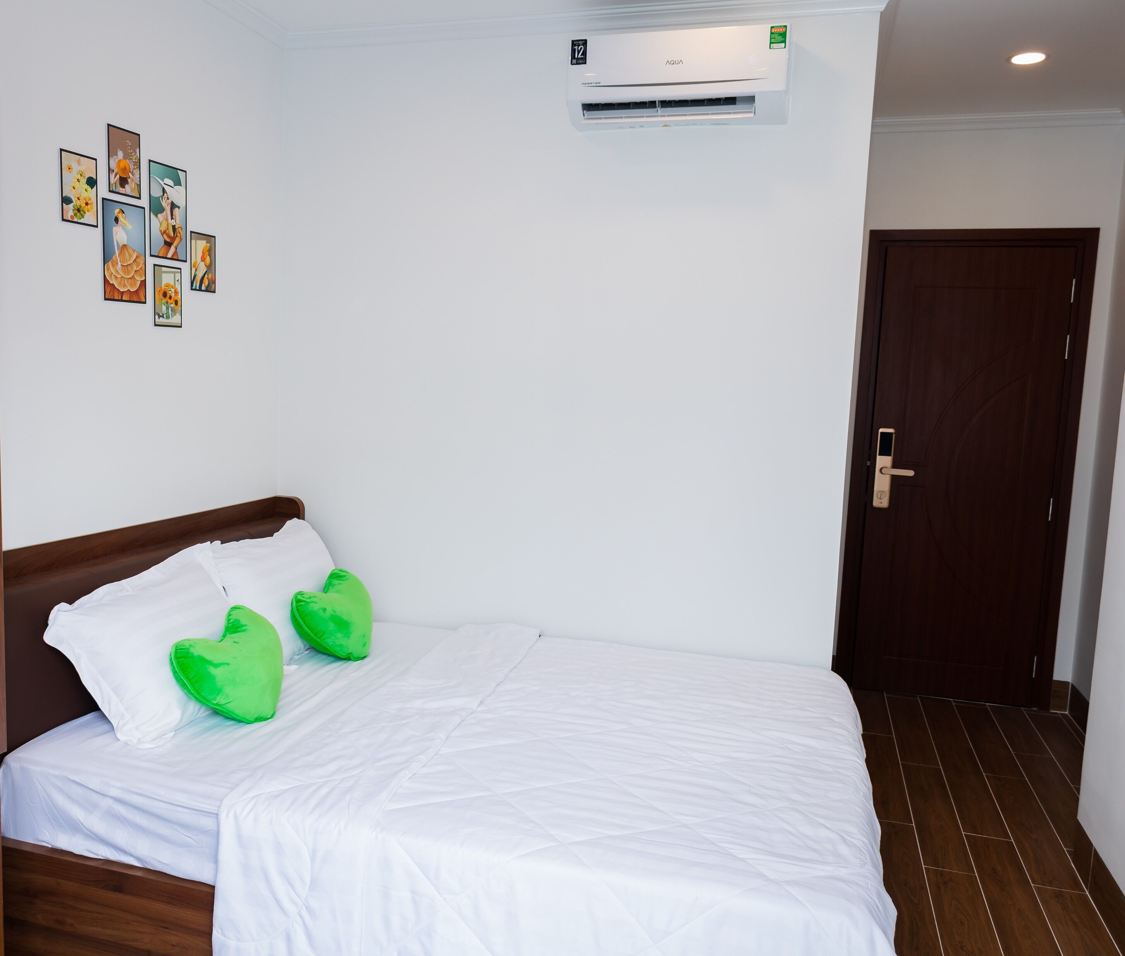 A hotel room with a bed, a wall-mounted air conditioner, and a door.