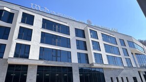 Un edificio moderno con amplios ventanales y un cartel que dice 