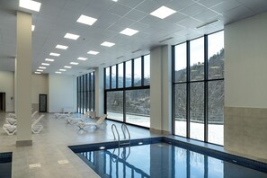 A large indoor swimming pool with clear views of a snowy landscape through large windows. - Ani Forest Hills Hotel and Resort (Dilijan)