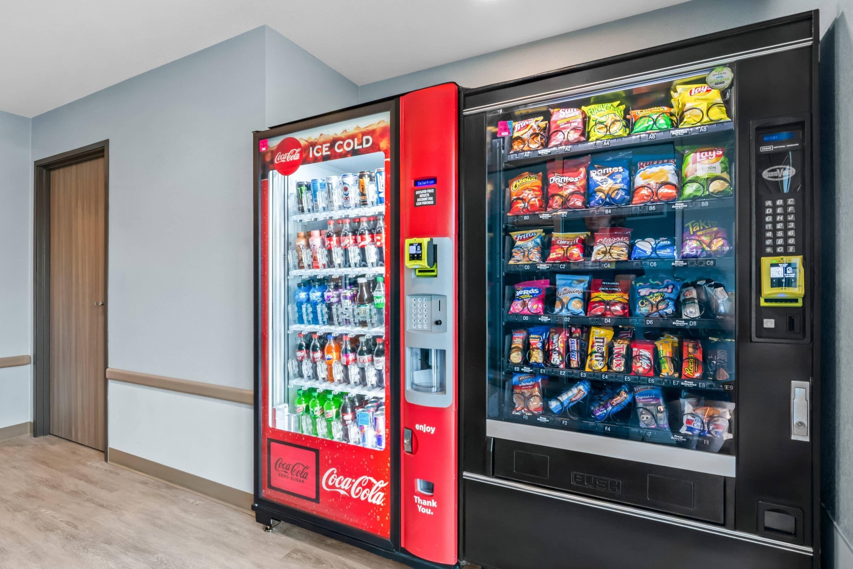 Máquina de vendas com opções de Coca-Cola e salgadinhos.