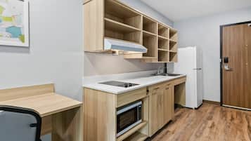 Una cocina compacta con microondas, estufa y armarios de madera.