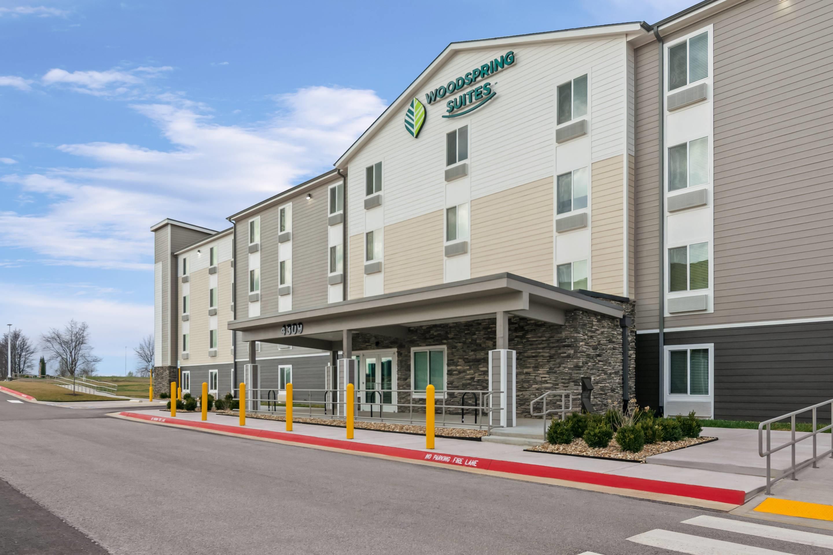 A multi-story hotel with a flat roof, a covered entrance, and a fire lane marked on the pavement.
